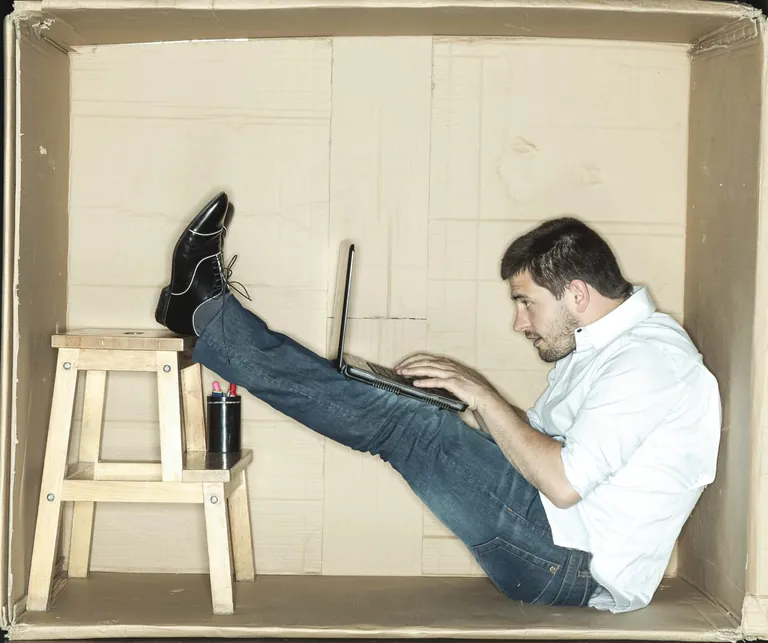 Mann in kleinem B&uuml;ro aus Pappe