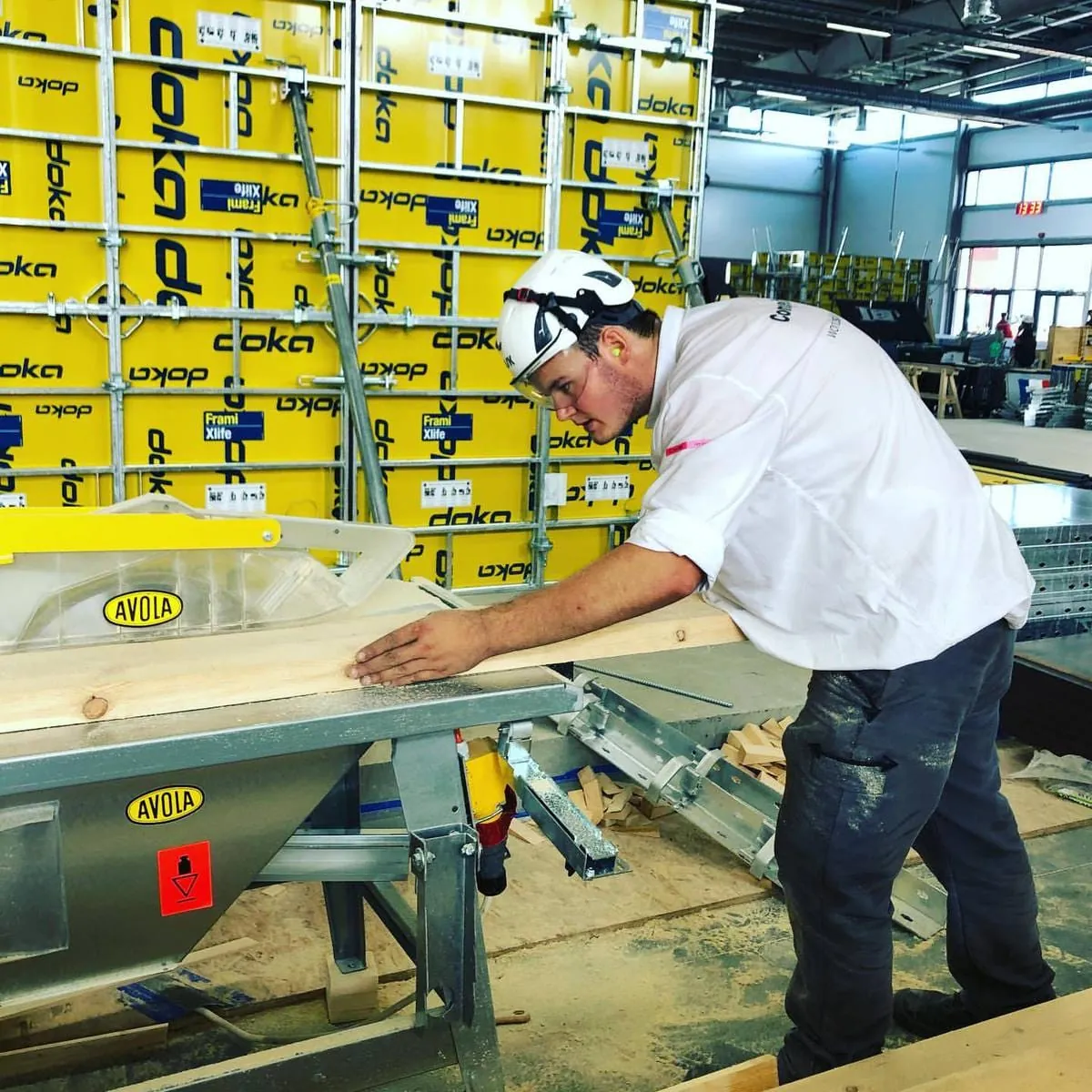 Stahlbetonbauer Niklas Berroth konzentriert sich voll und ganz auf die Säge, um den Balken exakt anzupassen.