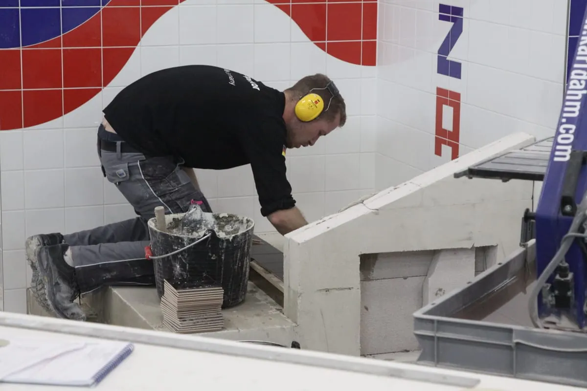 Fliesenleger Janis Gentner macht sich an das Duschpodest.