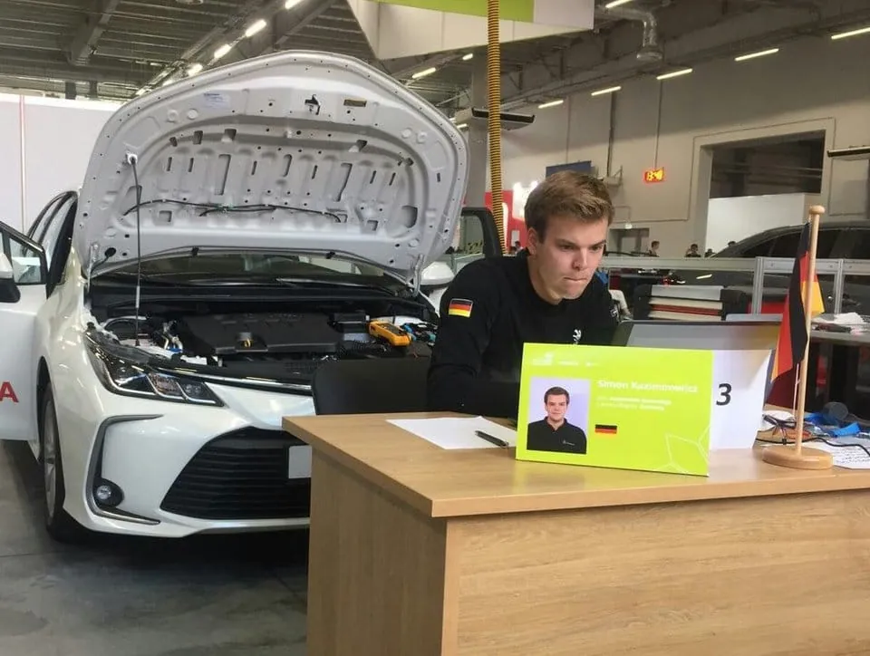 Kfz-Mechatroniker Simon Kazimirowicz sitzt wie gebannt an seinem Laptop.