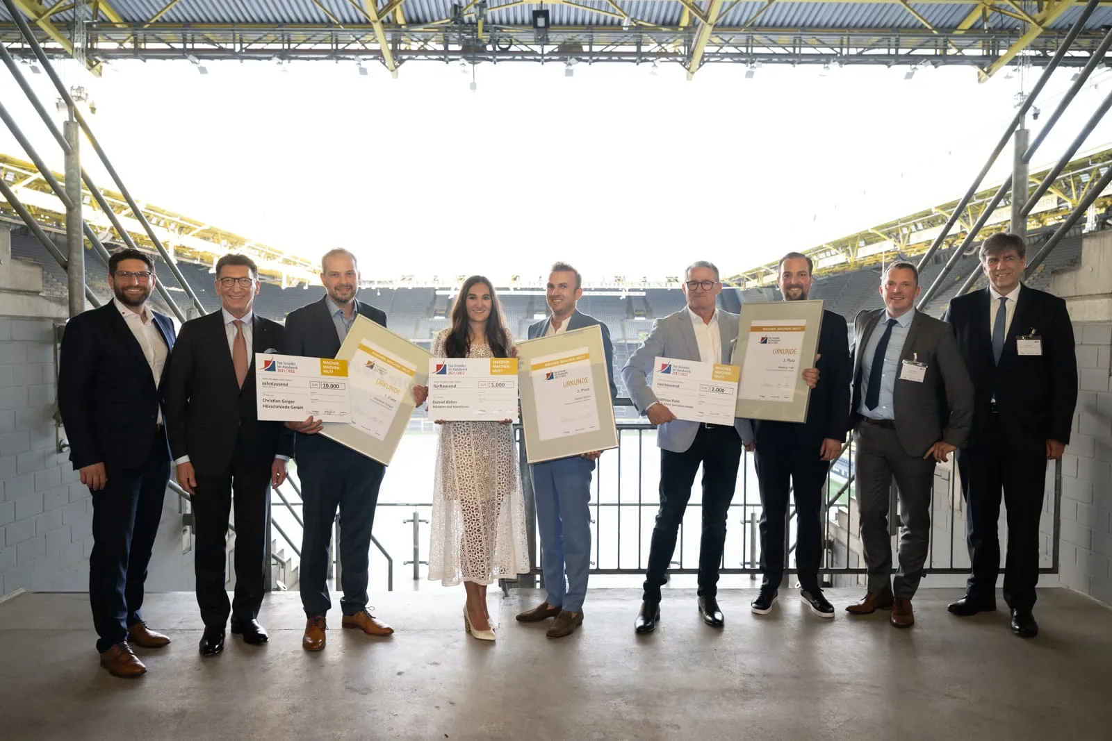 Siegerbild: Die Preisträger zusammen mit den Laudatoren vor der Kulisse der Dortmunder Südtribüne.