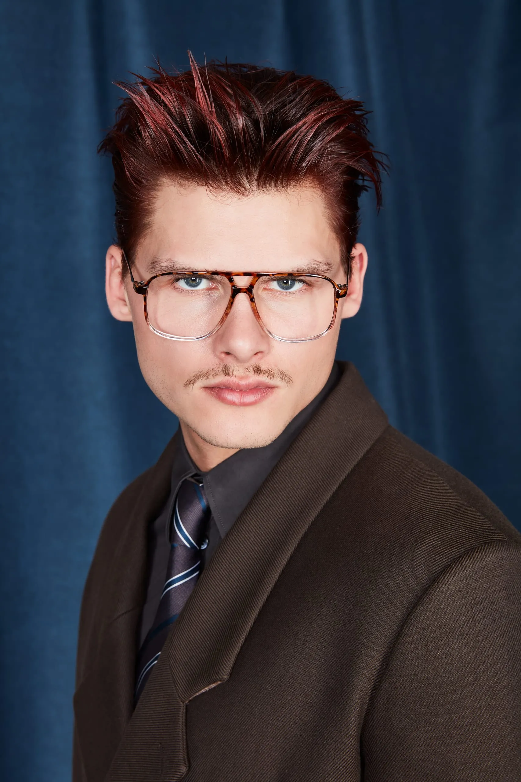 New Biz (Serie D2) Für den smarten Wet Look wird das gesamte Haar zurückgegelt. Damit die Frisur nicht zu konservativ und steif wirkt, ist es wichtig, das Styling locker und wie zufällig wirken zu lassen. Auch in der Business-Variante sorgt das mutige Rot für den modischen Kick. Damit kann der Herbst kommen!