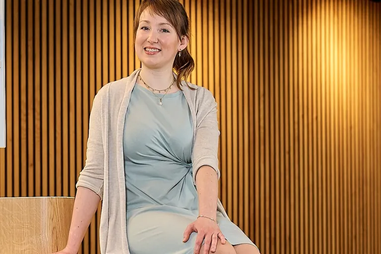 Ihre Schultern bedeckt sie mit einer lang&auml;rmligen Strickjacke in Beige.