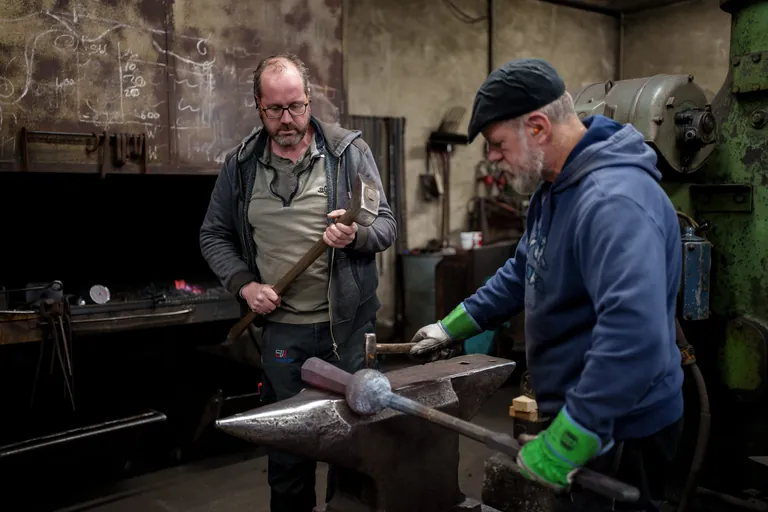 Gesch&auml;ftsf&uuml;hrer Martin Wensauer (li.) und ein Meisterschmied arbeiten an einem Glockenkl&ouml;ppel im Rottaler Hammerwerk f&uuml;r Notre-Dame.
