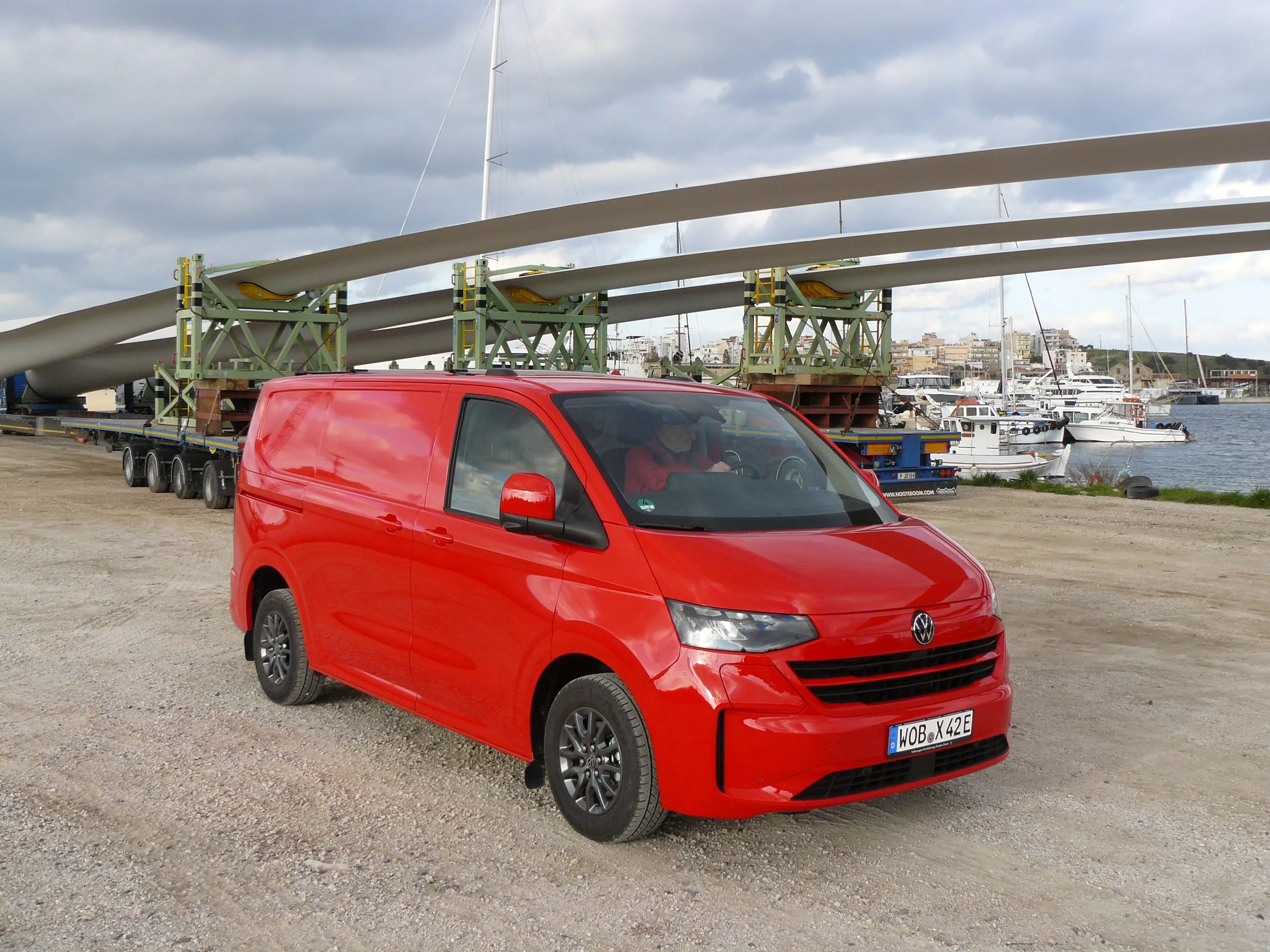 Rot vor Eifer: e-Transporter unter Windradflügeln