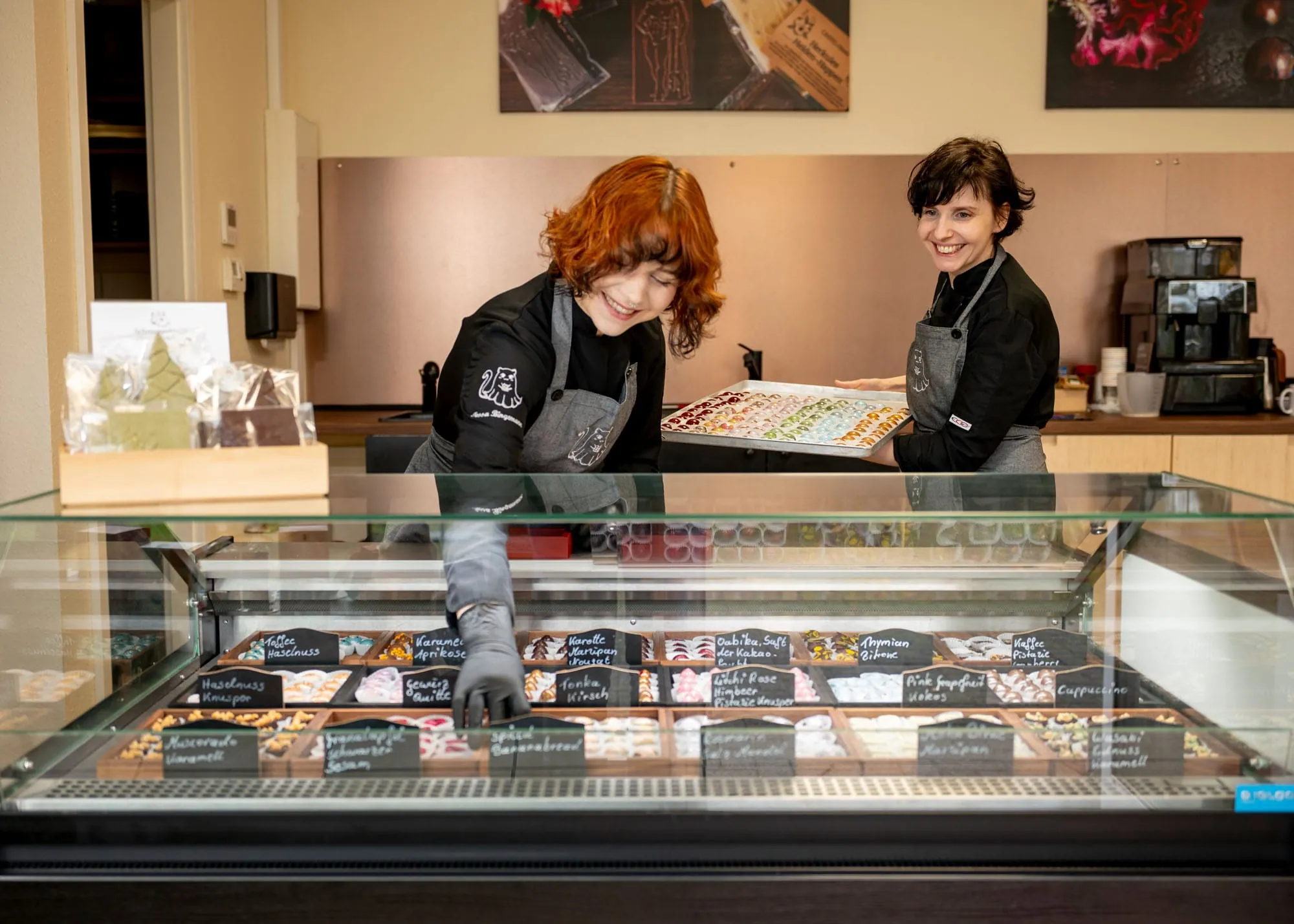 Frische Vielfalt: Tessa Bingemann und Amanda Dahl bestücken die Theke mit neuen Pralinen – jede Woche gibt es andere Sorten zu entdecken.