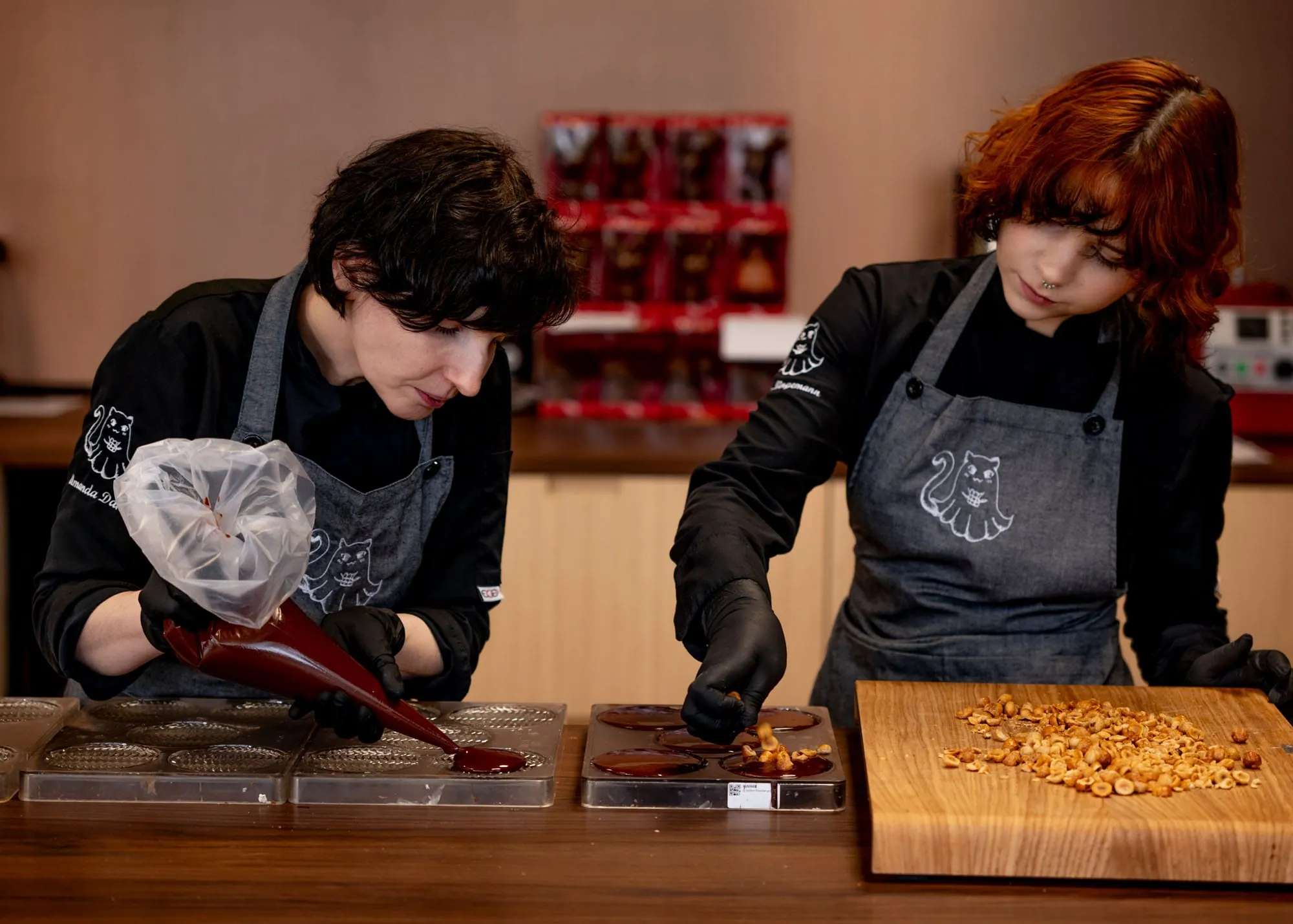 Feinschliff mit ruhiger Hand: Mit großer Konzentration verzieren die beiden Konditorinnen ihre Pralinen.