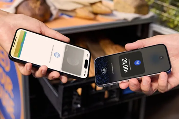 Zwei Personen halten ihre Smartphones aneinander, um eine kontaklose Zahlung durchzuführen.