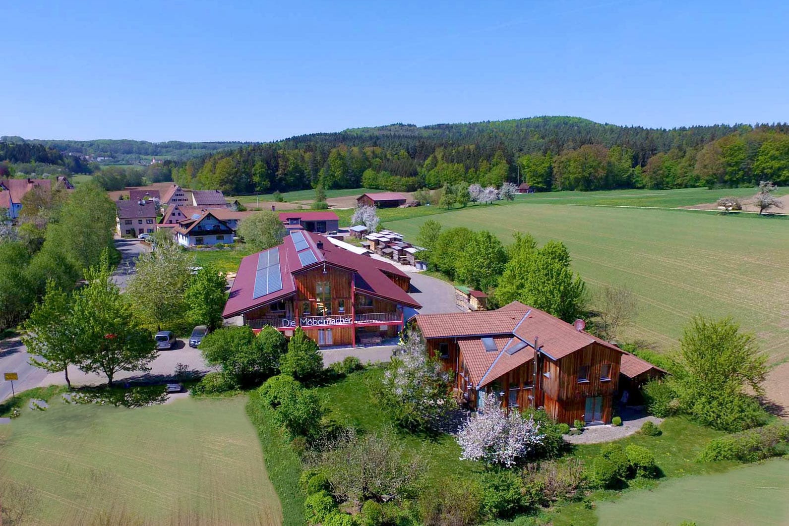 Auf dem großzügigen Gelände der Möbelmacher in Unterkrumbach ist viel Platz für Werkstatt, Holzlager und ein Musterhaus, das auch als Wohnhaus für die Unternehmerfamilie dient.