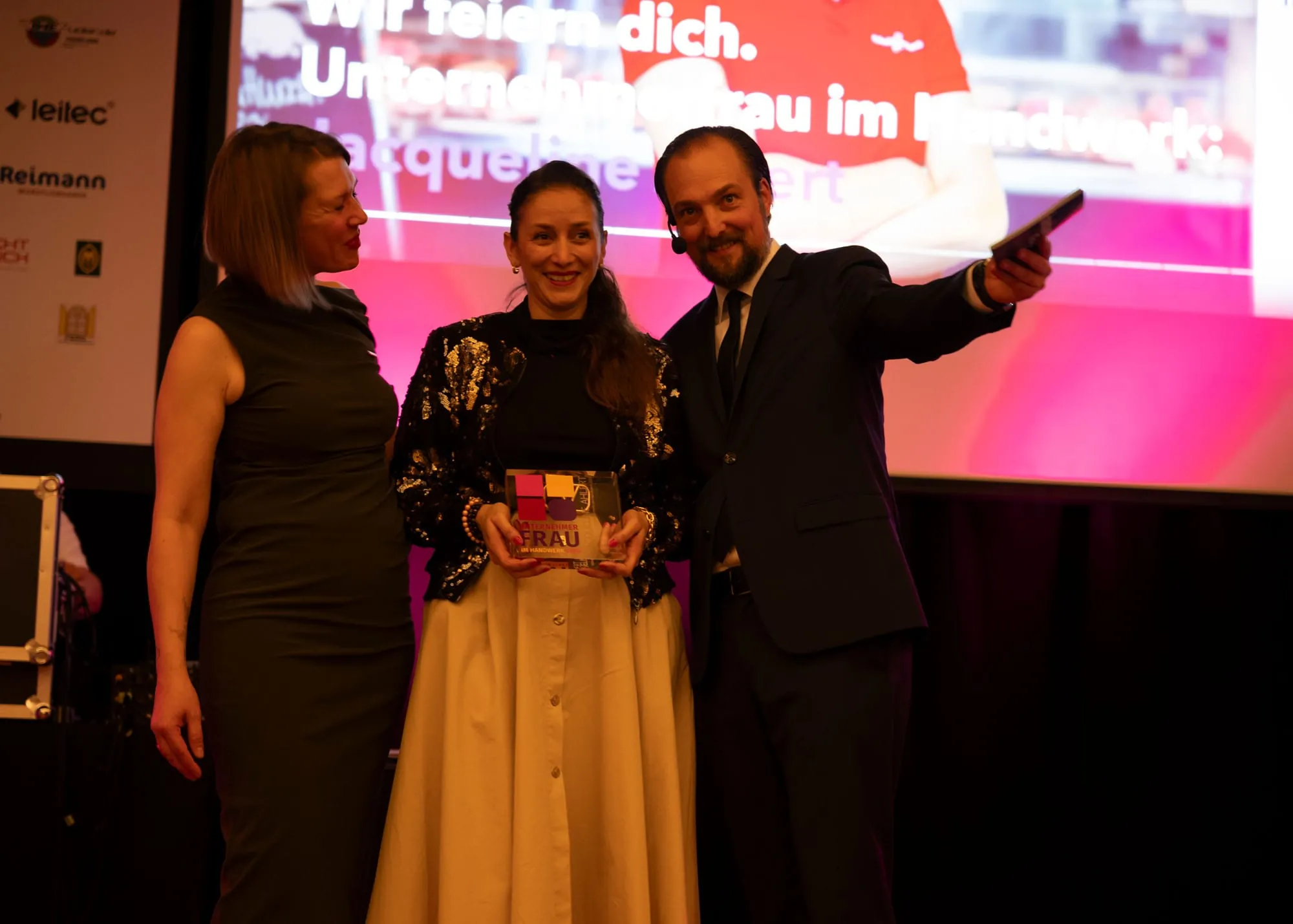 Unsere Gewinnerin zwischen den Gastgebern des Abends: Die Moderation der Veranstaltung übernahmen die UFH-Bundesvorsitzende Katja Lilu Melder (li.) und Patrick Neumann, Chefredakteur von handwerk magazin.